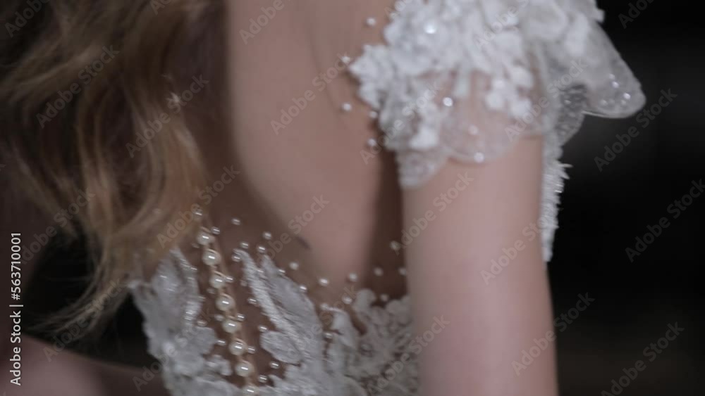 lady with long loose hair tries on elegant wedding dress with decorative sparkling embroidery on bodice back close view lady with long loose hair tries on elegant wedding dress with decorative sparkling embroidery on bodice back close view