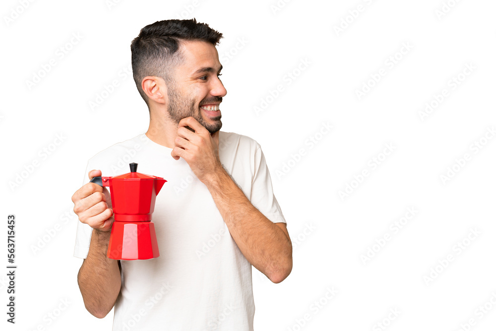 Young caucasian man holding coffee pot over isolated chroma key background thinking an idea and looking side Young caucasian man holding coffee pot over isolated chroma key background thinking an idea and looking side