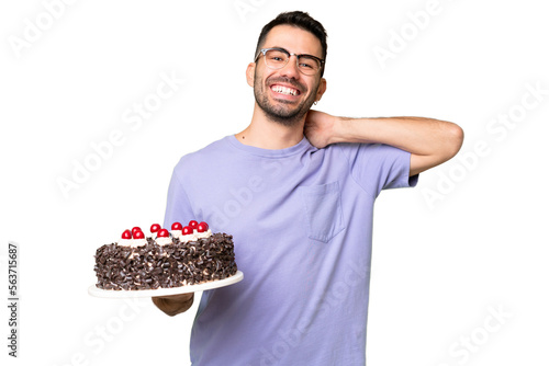 Young caucasian man holding birthday cake isolated on green chrome background laughing