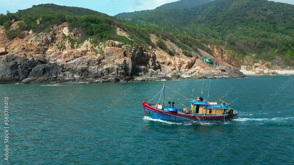 On sunny morning, fishing boat hurries to sea to catch seafood. Fishermen Nha Trang in Vietnam are sailing on a against the backdrop of a beautiful landscape and a wonderful mountains on a sunny day. On sunny morning, fishing boat hurries to sea to catch seafood. Fishermen Nha Trang in Vietnam are sailing on a against the backdrop of a beautiful landscape and a wonderful mountains on a sunny day.