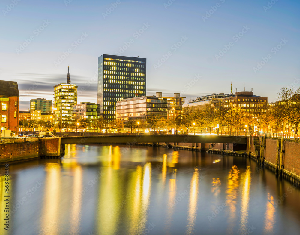 Fototapeta premium Hamburg city buildings and Hauptkirche St. Katharinen tower illuminated at night on Zollkanal, Germany