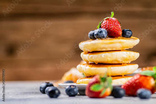 A bunch of homemade pancakes with berries. 