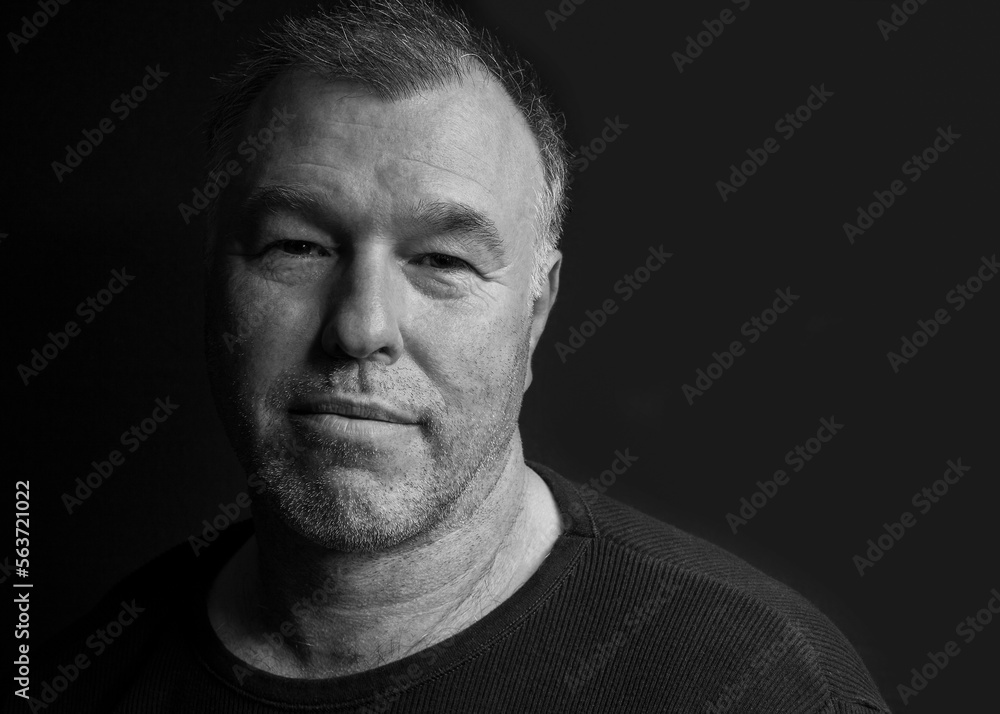 Black and white low key portrait of a handsome middle-aged man. Black and white low key portrait of a handsome middle-aged man.