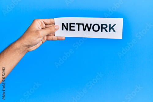 Hand of caucasian man holding paper with network word over isolated blue background