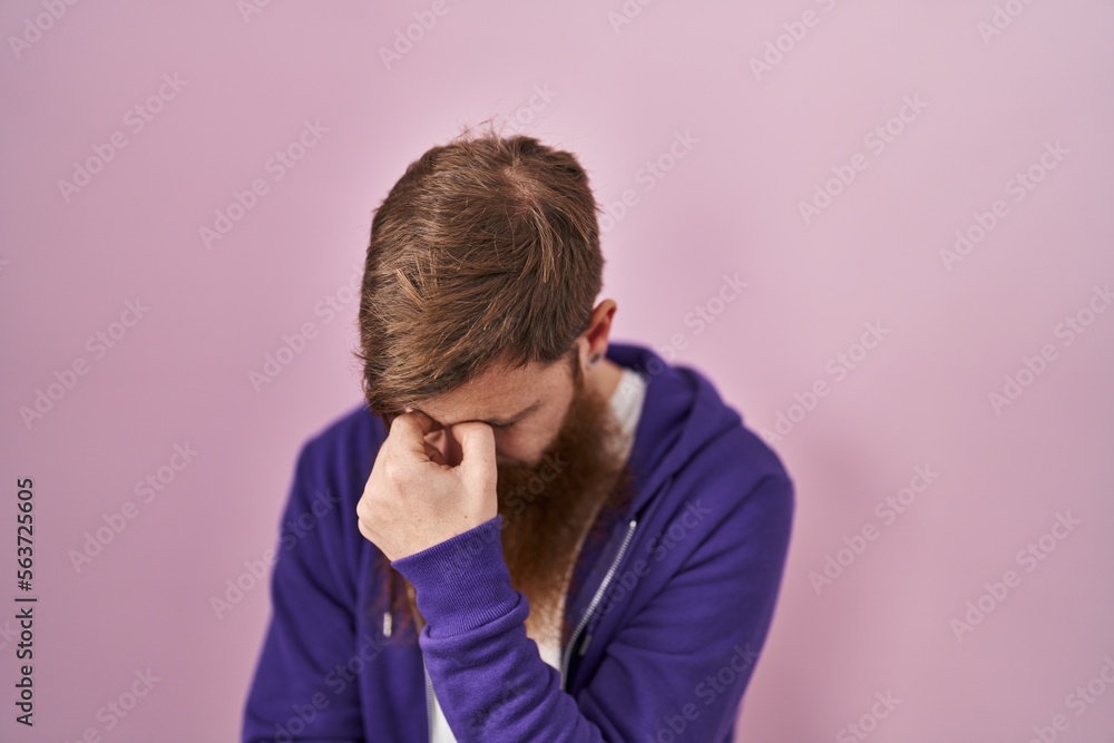Caucasian man with long beard standing over pink background tired rubbing nose and eyes feeling fatigue and headache. stress and frustration concept. Caucasian man with long beard standing over pink background tired rubbing nose and eyes feeling fatigue and headache. stress and frustration concept.