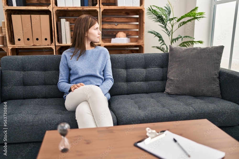 Young brunette woman at consultation office looking to side, relax profile pose with natural face with confident smile.
