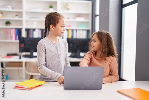 Two kids students using computer studying at classroom