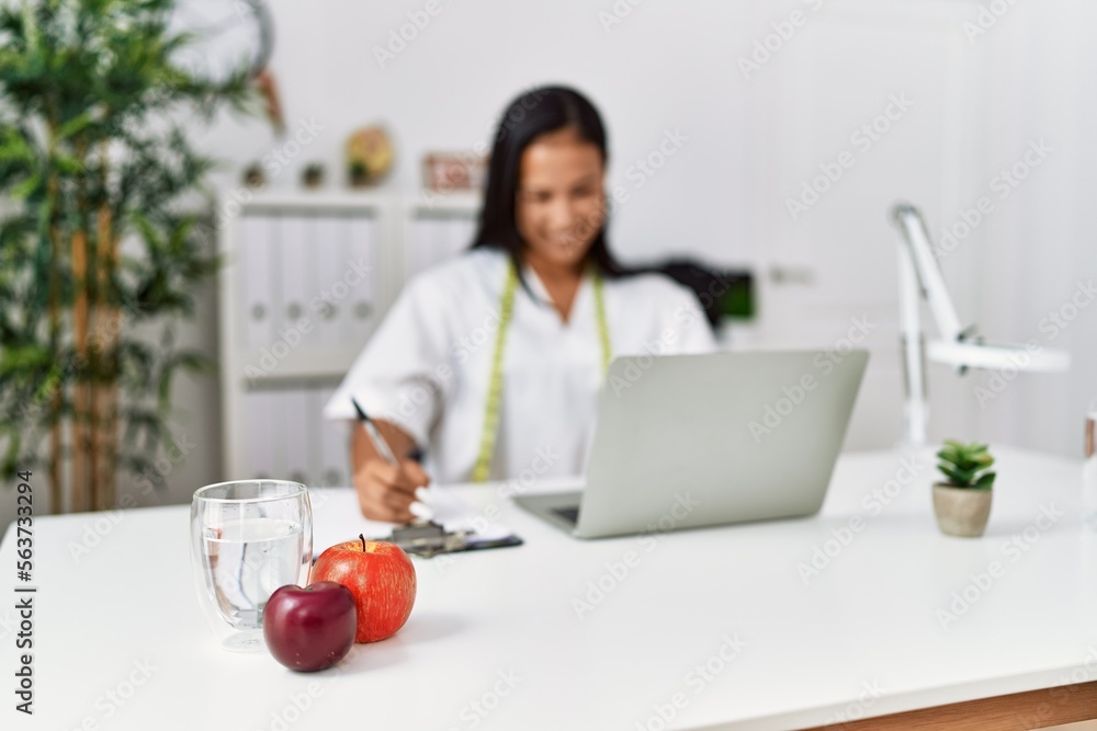 Young latin woman wearing nutritionist uniform working at clinic Young latin woman wearing nutritionist uniform working at clinic
