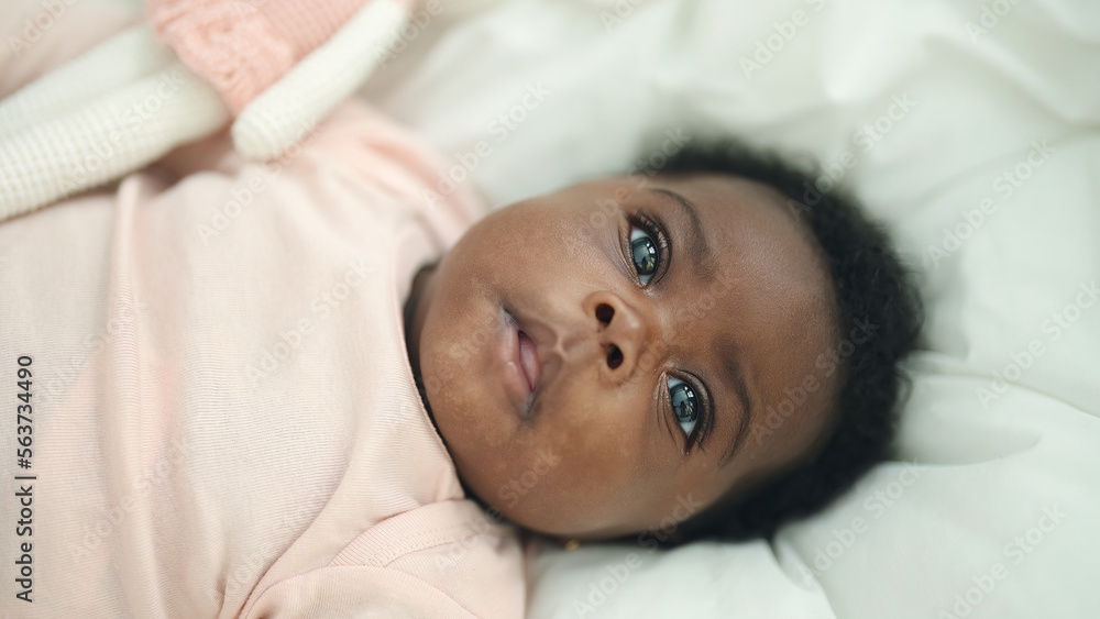 African american baby lying on bed with relaxed expression at bedroom African american baby lying on bed with relaxed expression at bedroom