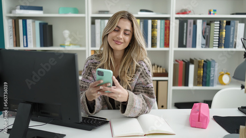 Young blonde woman student using computer and smartphone studying at library university © Krakenimages.com