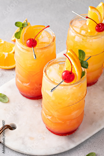 Rum punch in tiki glasses with orange slices and a cherry