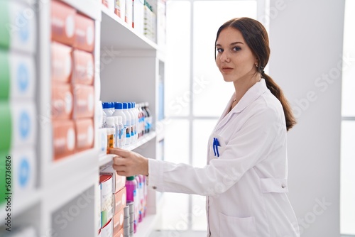 Young woman pharmacist organize shev at pharmacy photo