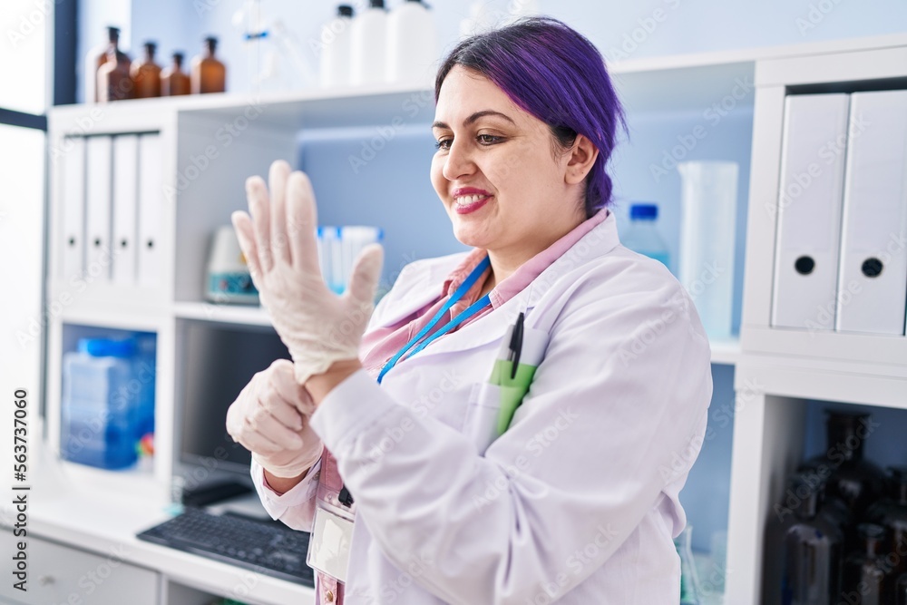 Young beautiful plus size woman scientist smiling confident wearing gloves at laboratory Young beautiful plus size woman scientist smiling confident wearing gloves at laboratory