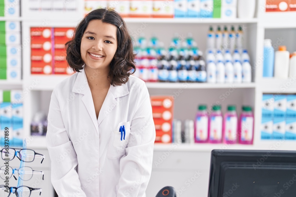 Young woman pharmacist smiling confident standing at pharmacy