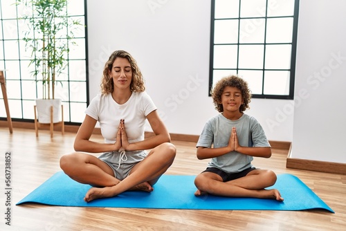 Mother and son smiling confident training yoga at sport center