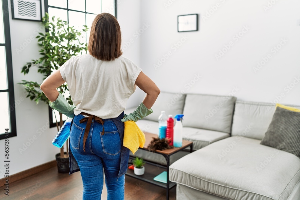 Middle age hispanic woman working as housekeeper ready to clean at home Middle age hispanic woman working as housekeeper ready to clean at home