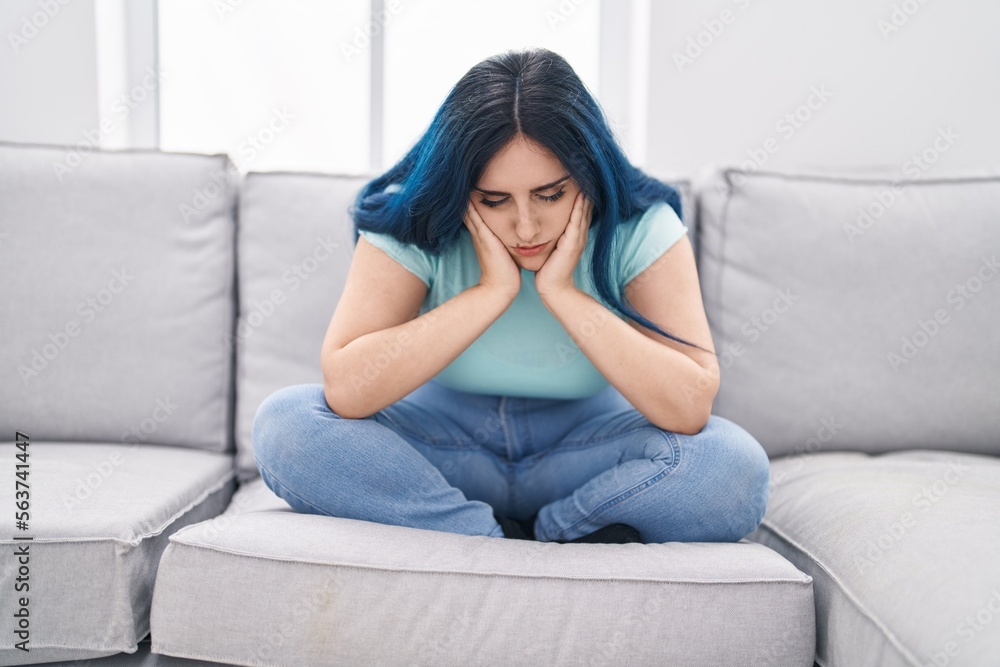 Young caucasian woman stressed sitting on sofa at home Young caucasian woman stressed sitting on sofa at home