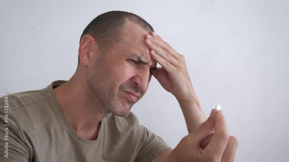 Man hold painkill from headache suffering. A stressed man suffering from headache and want to take a painkill. Man hold painkill from headache suffering. A stressed man suffering from headache and want to take a painkill.