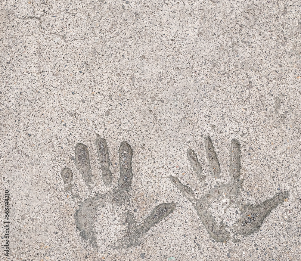 Two hand prints in white concrete pavement background and wallpaper texture. Copy space. Two hand prints in white concrete pavement background and wallpaper texture. Copy space.