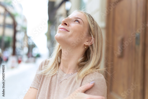 Young blonde woman breathing with closed eyes at street