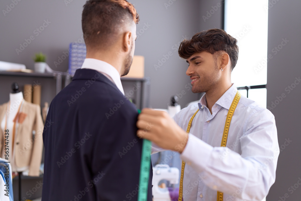 Two hispanic men tailor measuring chest client at atelier Two hispanic men tailor measuring chest client at atelier