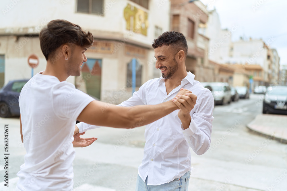Fototapeta premium Two hispanic men couple smiling confident dancing at street