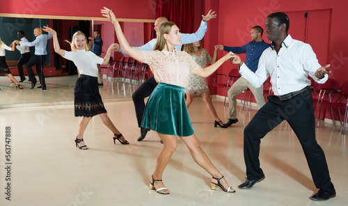 Portrait of young people dancing lindy hop in pairs in modern dance hall