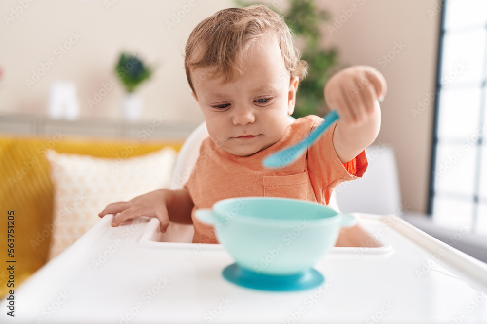 Adorable blond toddler sitting on highchair waiting to eat at home Adorable blond toddler sitting on highchair waiting to eat at home