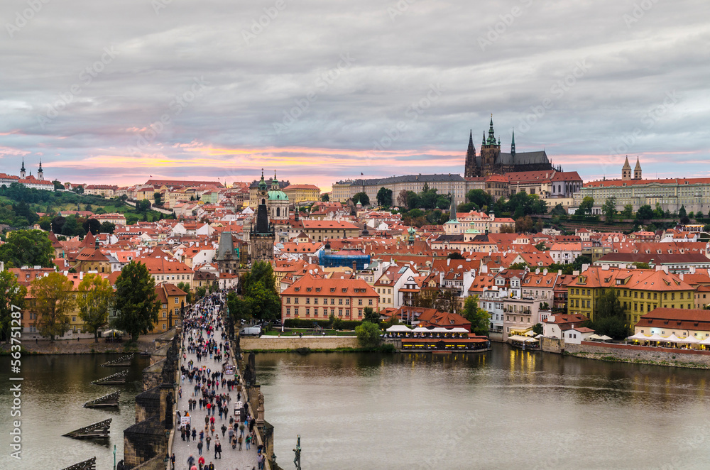 View at sunset from Old Town Bridge tower over the historical Charles bridge and Castle district with motion blur, Prague, Czech Republic