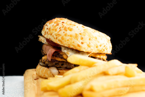 Burger cheese with potato in wooden table and black backgournd  photo