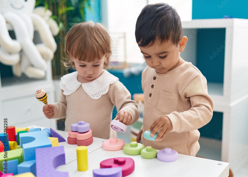 Two kids playing with construction blocks standing at kindergarten Two kids playing with construction blocks standing at kindergarten