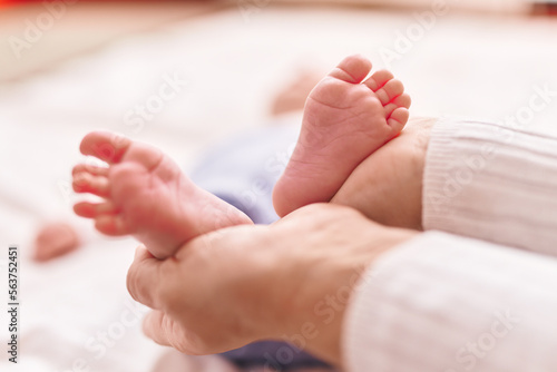 Mother and son lying on bed holding feet at bedroom © Krakenimages.com