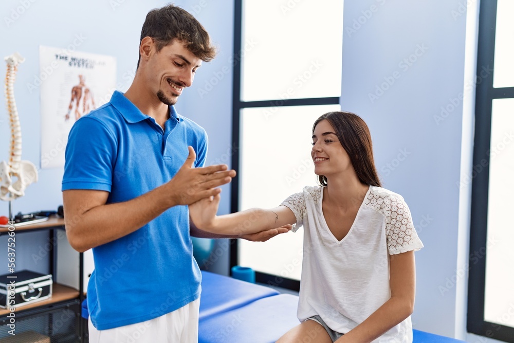 Man and woman wearing physiotherpy uniform having rehab session at clinic Man and woman wearing physiotherpy uniform having rehab session at clinic