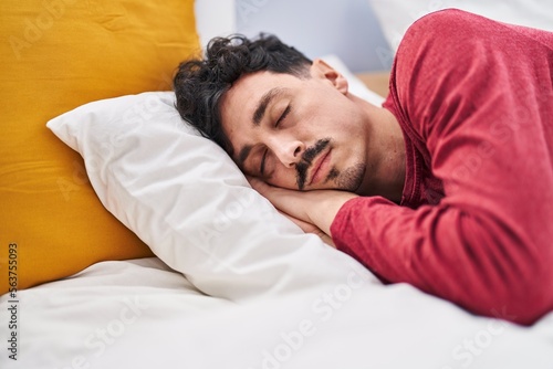 Young caucasian man lying on bed sleeping at bedroom