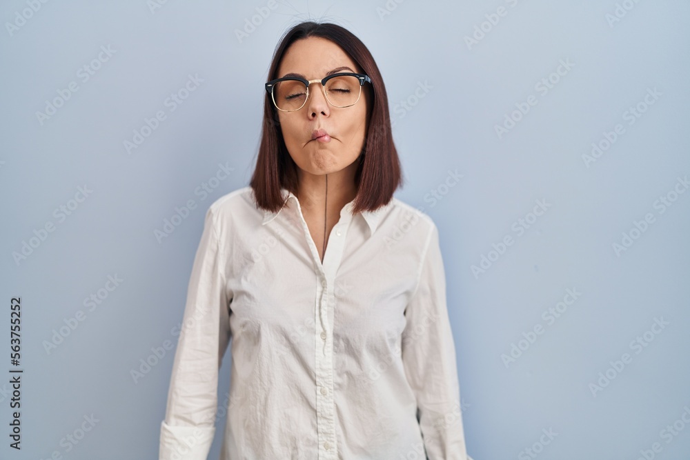 Young hispanic woman standing over white background making fish face with lips, crazy and comical gesture. funny expression. Young hispanic woman standing over white background making fish face with lips, crazy and comical gesture. funny expression.