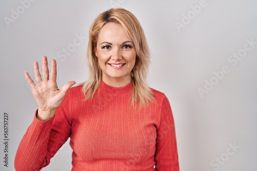 Wallpaper Mural Blonde woman standing over isolated background showing and pointing up with fingers number five while smiling confident and happy. Torontodigital.ca