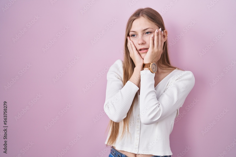 Young caucasian woman standing over pink background tired hands covering face, depression and sadness, upset and irritated for problem Young caucasian woman standing over pink background tired hands covering face, depression and sadness, upset and irritated for problem