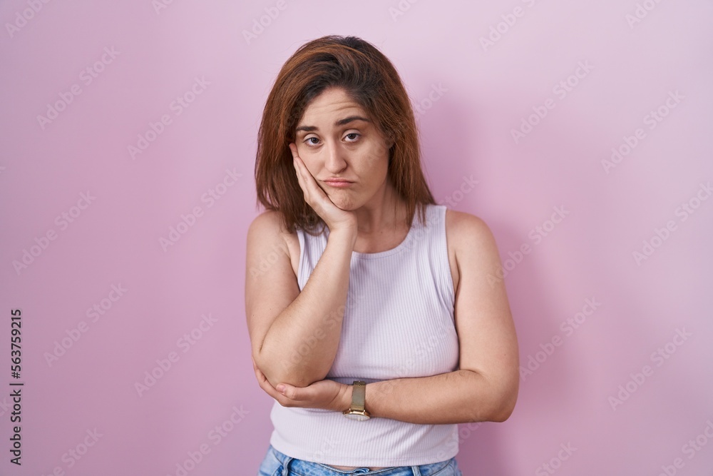 Brunette woman standing over pink background thinking looking tired and bored with depression problems with crossed arms. Brunette woman standing over pink background thinking looking tired and bored with depression problems with crossed arms.