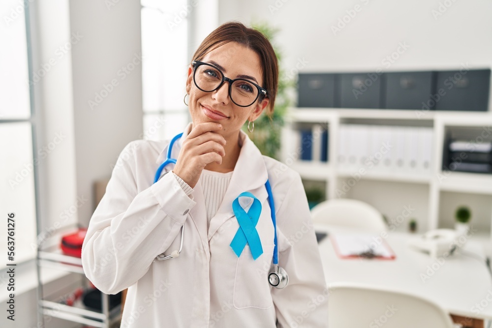 Young brunette doctor woman wearing stethoscope at the clinic looking confident at the camera smiling with crossed arms and hand raised on chin. thinking positive. Young brunette doctor woman wearing stethoscope at the clinic looking confident at the camera smiling with crossed arms and hand raised on chin. thinking positive.
