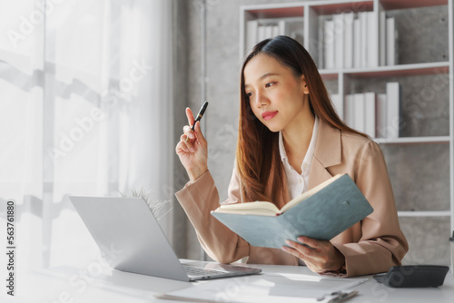 Young asia pretty entrepreneur busy woman in her private office working audit and calculating expense financial annual financial report balance sheet statement, checking inspection tax calculation