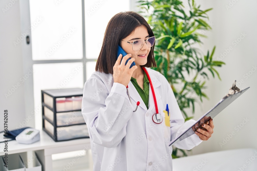 Young beautiful hispanic woman doctor smiling confident using sanitizer gel hands at clinic Young beautiful hispanic woman doctor smiling confident using sanitizer gel hands at clinic