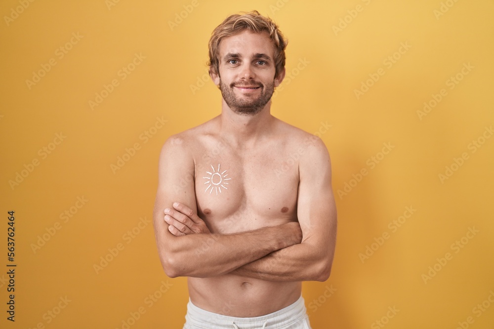 Caucasian man standing shirtless wearing sun screen happy face smiling with crossed arms looking at the camera. positive person.