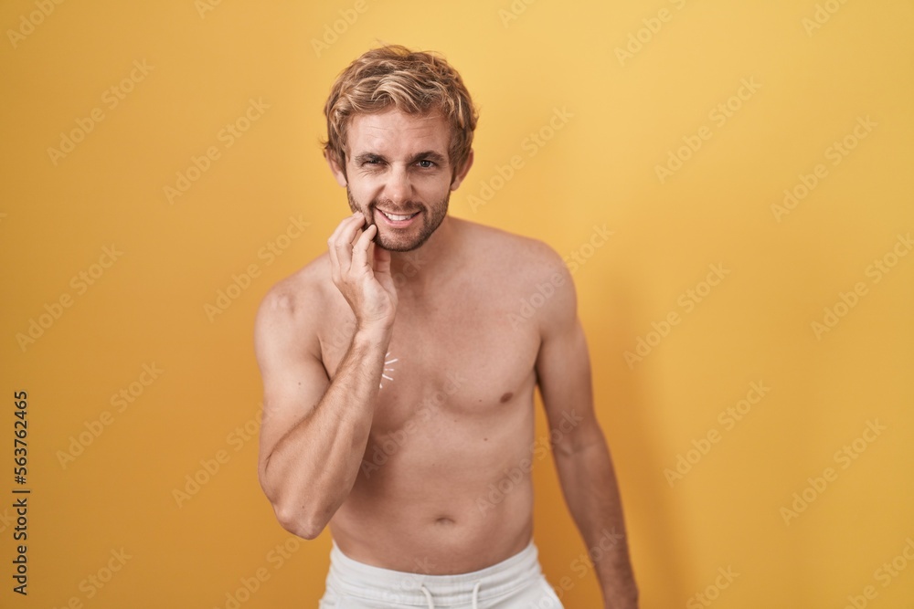 Caucasian man standing shirtless wearing sun screen touching mouth with hand with painful expression because of toothache or dental illness on teeth. dentist