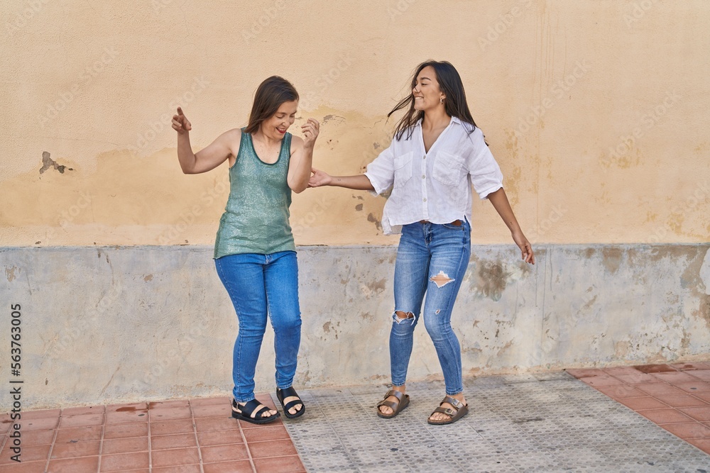 Two women mother and daughter smiling confident dancing at street Two women mother and daughter smiling confident dancing at street