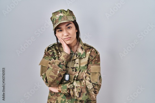 Young south asian woman wearing camouflage army uniform thinking looking tired and bored with depression problems with crossed arms.