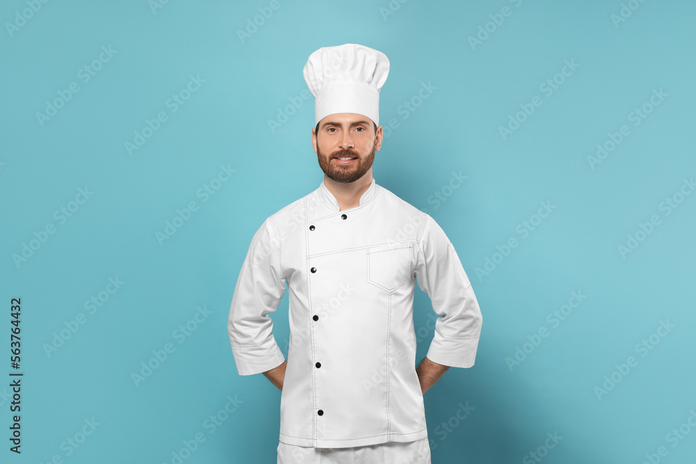 Smiling mature chef on light blue background