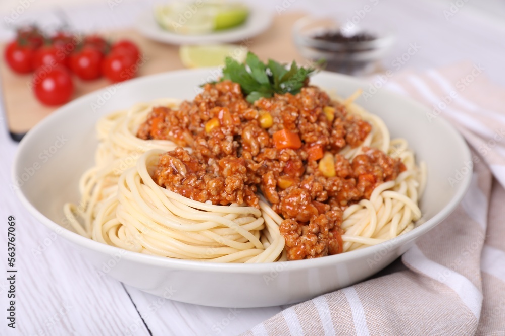 Tasty dish with fried minced meat, spaghetti, carrot and corn on white wooden table, closeup Tasty dish with fried minced meat, spaghetti, carrot and corn on white wooden table, closeup