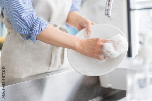 Foto キッチンで環境と肌に優しい食器用洗剤で素手で食器を洗う人