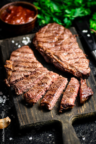 Sliced grilled steak on a cutting board.