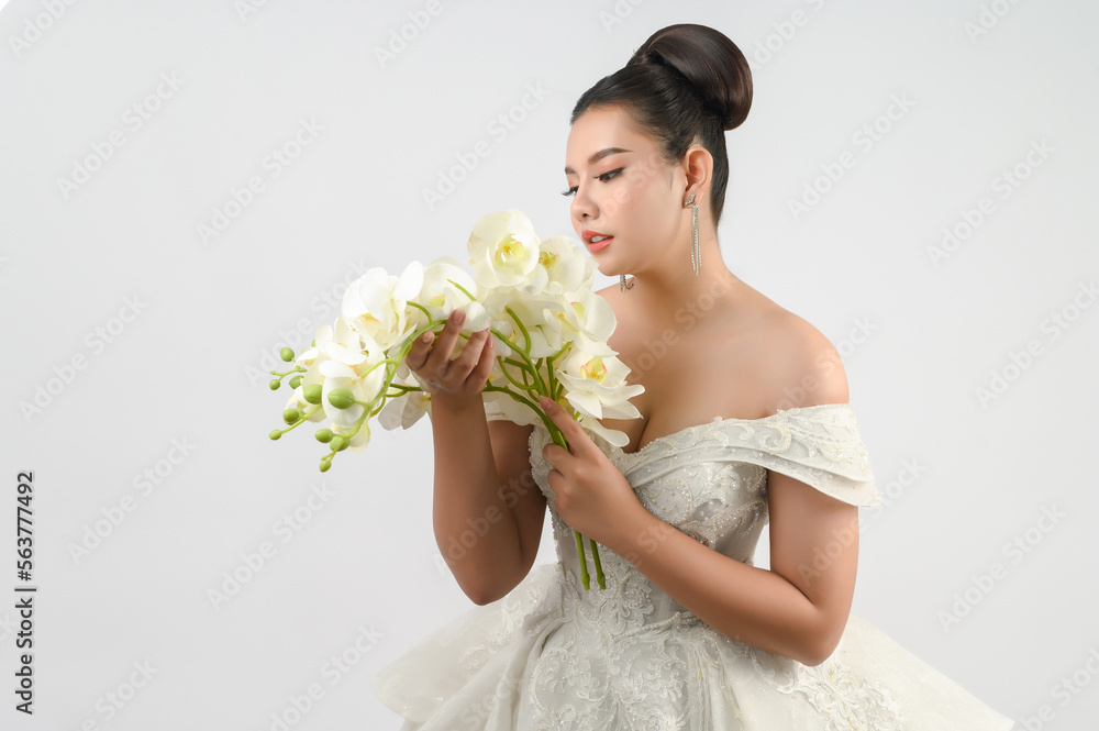 Young asian beautiful bride with orchid bouquet on white background Young asian beautiful bride with orchid bouquet on white background